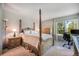 Sun-filled bedroom with four poster bed, adjacent desk, and large windows providing natural light at 1240 Lone Scout Lookout, Monument, CO 80132