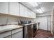Well-equipped laundry room with stainless steel washer and dryer and ample storage at 1240 Lone Scout Lookout, Monument, CO 80132