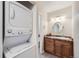 Bathroom featuring a washer/dryer combo, vanity with marble countertop, and an oval mirror at 519 Wright St # 304, Lakewood, CO 80228