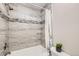Bathroom showcasing a tub/shower combo with decorative gray tile and a marble border at 519 Wright St # 304, Lakewood, CO 80228