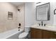 Bright bathroom featuring a shower over tub, tiled walls, modern vanity, and sleek fixtures at 1737 Lowell Blvd, Denver, CO 80204