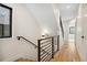 A modern staircase with wood treads, a black metal railing, and white walls at 1737 Lowell Blvd, Denver, CO 80204