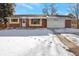 Ranch style home with attached garage and snow-covered front yard at 8714 W Burgundy Dr, Littleton, CO 80123