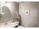 Neutral colored powder bathroom with modern round mirror and ample counter space at 943 S Fairplay St, Aurora, CO 80012