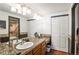 Primary bath featuring granite counters, a dual sink vanity and large wall mirror at 943 S Fairplay St, Aurora, CO 80012
