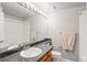 Bright bathroom with granite counter, decorative mirror, and shower-tub combo at 943 S Fairplay St, Aurora, CO 80012