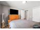 Bedroom with wooden dresser and modern TV, complemented by a closet and neutral carpet at 943 S Fairplay St, Aurora, CO 80012