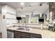 Well-lit kitchen featuring modern countertops, stainless steel sink, and views into the living area at 943 S Fairplay St, Aurora, CO 80012