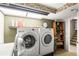 Bright laundry room features front loading washer/dryer and convenient storage shelf at 943 S Fairplay St, Aurora, CO 80012