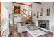 Spacious living room featuring modern fireplace, wooden stairs, and neutral decor at 943 S Fairplay St, Aurora, CO 80012