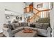 Open-concept living room with modern decor, stairs, and easy access to the kitchen at 943 S Fairplay St, Aurora, CO 80012