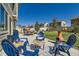 Inviting backyard patio featuring modern blue Adirondack seating, a dining area, and well-maintained landscaping at 458 Highlands Cir, Erie, CO 80516