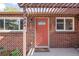 Charming brick home featuring a vibrant coral front door and a stylish pergola entrance at 3316 N Glencoe St, Denver, CO 80207