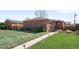 Quaint brick home with a well-maintained lawn and charming landscaping at 3316 N Glencoe St, Denver, CO 80207