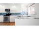 Modern kitchen featuring white cabinets, stainless steel appliances, and granite countertops at 3316 N Glencoe St, Denver, CO 80207