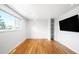 Bright living room featuring gleaming hardwood floors, large windows and built-in shelving at 3316 N Glencoe St, Denver, CO 80207