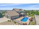 Backyard aerial view of the property with a fenced pool, spa, patio, well-manicured landscaping, and a neutral-colored house at 8655 E 130Th Ave, Thornton, CO 80602