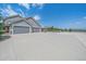 Spacious three car garage featuring neutral grey doors, stone accents, and a large concrete driveway at 8655 E 130Th Ave, Thornton, CO 80602