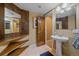 Unique powder room featuring a pedestal sink, wooden accents, and a doorway to another area at 8655 E 130Th Ave, Thornton, CO 80602