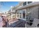 View of the back porch with seating, access to the house through glass doors, and a brick facade at 5252 W 68Th Ave, Arvada, CO 80003