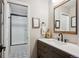 Bright bathroom featuring a modern vanity, stylish mirror, and a beautifully tiled shower at 7312 Marshall Rd, Larkspur, CO 80118