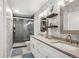 Modern bathroom featuring a double sink vanity, stylish wallpaper, and glass enclosed shower at 7312 Marshall Rd, Larkspur, CO 80118