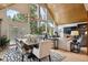 Sunlit dining area with views, wood ceiling, chandelier, and access to outdoor living space at 7312 Marshall Rd, Larkspur, CO 80118