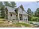 Gray two-story home with a steep roofline and modern architectural details surrounded by mature trees and landscaping at 7312 Marshall Rd, Larkspur, CO 80118