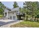 Charming exterior with large deck and two car garage surrounded by mature trees at 7312 Marshall Rd, Larkspur, CO 80118