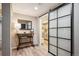 Hallway features hardwood floors, decorative mirror, and a sliding barn door to the kitchen at 7312 Marshall Rd, Larkspur, CO 80118