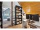 Charming home office with wood-paneled ceiling, built-in shelving and desk with view to the bedroom at 7312 Marshall Rd, Larkspur, CO 80118