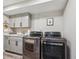 Convenient laundry room equipped with washer, dryer, utility sink, and ample cabinet space at 7312 Marshall Rd, Larkspur, CO 80118