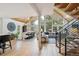 Open-concept living room featuring hardwood floors, high ceilings, large windows, and a dining area with modern decor at 7312 Marshall Rd, Larkspur, CO 80118
