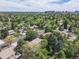 An aerial shot capturing a neighborhood, mature trees, and the city skyline in the distance at 3775 S Poplar St, Denver, CO 80237