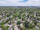 An aerial view capturing a neighborhood, mature trees, and the city skyline in the distance at 3775 S Poplar St, Denver, CO 80237