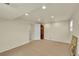 Large, well-lit basement with carpet flooring, white walls, and a grandfather clock at 3775 S Poplar St, Denver, CO 80237