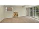 Cozy carpeted room with a walk-out sliding door, a window, and light neutral walls at 3775 S Poplar St, Denver, CO 80237