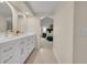 Bright bathroom features a dual vanity, white cabinets, and an adjacent primary bedroom at 3775 S Poplar St, Denver, CO 80237