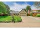 Inviting one-story home with lush green lawn, mature trees, and a long driveway at 3775 S Poplar St, Denver, CO 80237