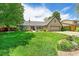 Inviting one-story home with lush green lawn, mature trees, and a long driveway at 3775 S Poplar St, Denver, CO 80237