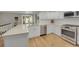 Modern kitchen featuring white cabinets, quartz countertops, stainless steel appliances, and hardwood floors at 3775 S Poplar St, Denver, CO 80237
