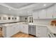 Contemporary kitchen with stainless steel appliances, white cabinets, and a view of the stairs at 3775 S Poplar St, Denver, CO 80237