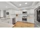 Bright kitchen featuring stainless steel appliances, white cabinets, and light hardwood floors at 3775 S Poplar St, Denver, CO 80237