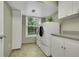 Bright laundry room featuring modern washer and dryer, storage cabinets and a window view at 3775 S Poplar St, Denver, CO 80237