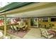 Covered patio featuring a dining area, tv, and outdoor furniture for entertaining with brick detail at 3775 S Poplar St, Denver, CO 80237