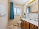 Bathroom featuring a wood vanity, tile floors, and updated fixtures at 3871 W Saratoga Ave, Littleton, CO 80123