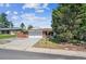 Charming brick home with an attached garage and driveway, lush lawn, and mature trees at 3871 W Saratoga Ave, Littleton, CO 80123