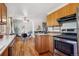 Eat-in kitchen featuring wooden cabinets, stainless steel appliances, and hardwood floors at 3871 W Saratoga Ave, Littleton, CO 80123