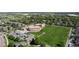 Wide aerial shot of school and playing field, surrounded by tree-lined neighborhood at 652 Ulster Way, Denver, CO 80230
