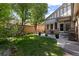 Backyard showcasing a well-manicured lawn, mature trees, patio area, and a cozy outdoor seating arrangement at 652 Ulster Way, Denver, CO 80230